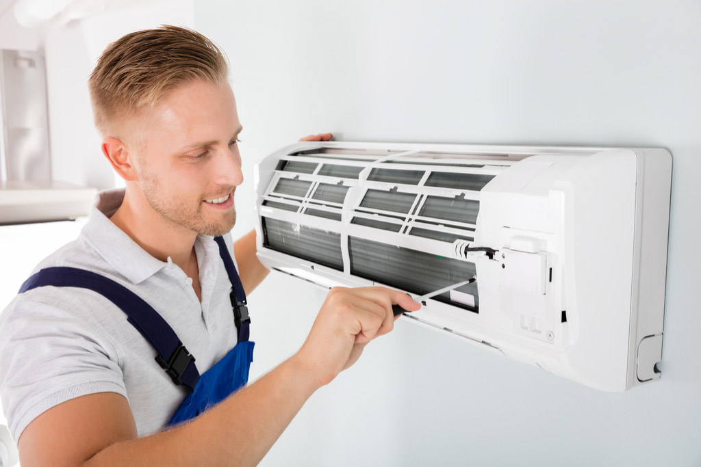 HVAC technician cleaning and repairing a ductless mini split AC in Golden, CO