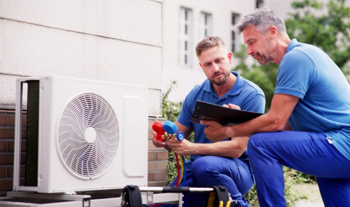 HVAC technicians reviewing an outdoor air conditioning unit in Golden, CO