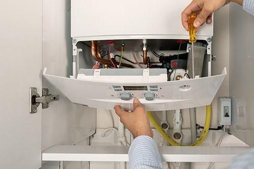HVAC technician repairing an indoor boiler in Golden