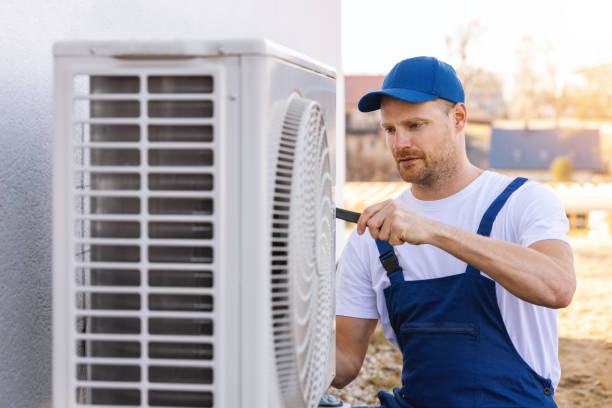 HVAC technician servicing an outdoor air conditioning unit in Golden