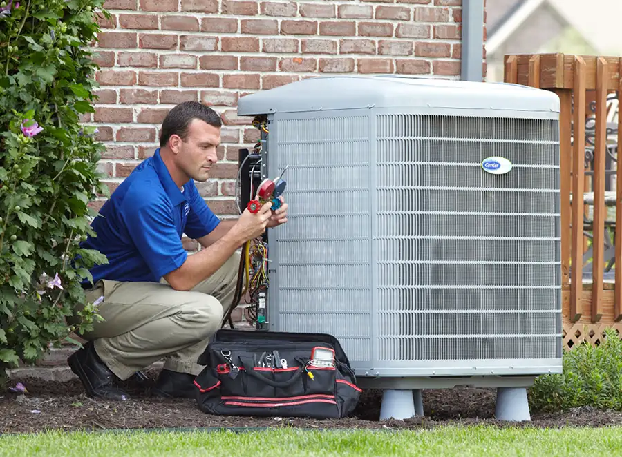 HVAC technician inspecting an outdoor air conditioning unit in Golden