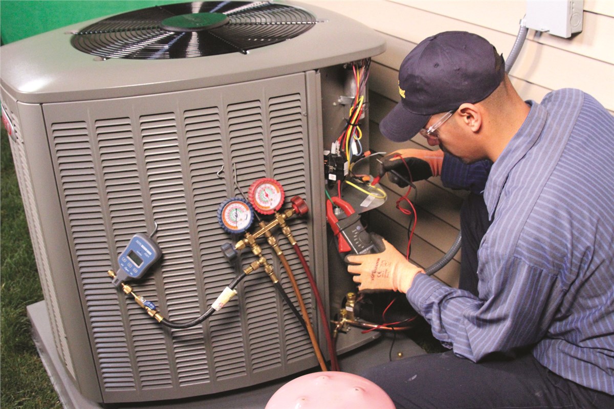 HVAC technician testing an outdoor air conditioning unit in Golden