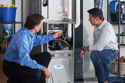 HVAC technician explaining furnace repair and maintenance to a homeowner in Golden, CO