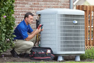 HVAC technician inspecting an outdoor air conditioning unit in Golden, CO